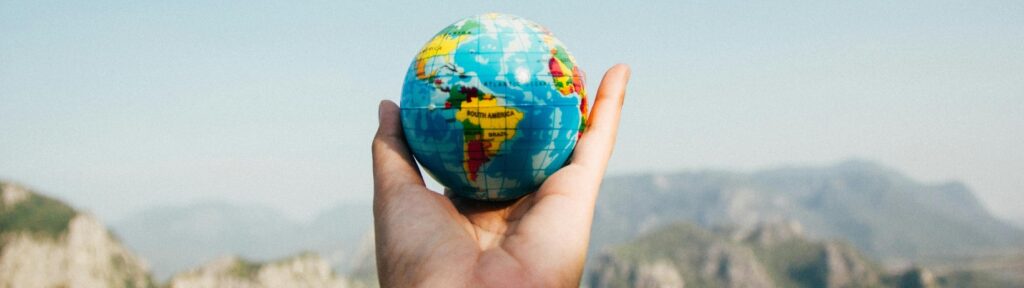 Hand holding a small globe representing global travel and Medicare coverage abroad.